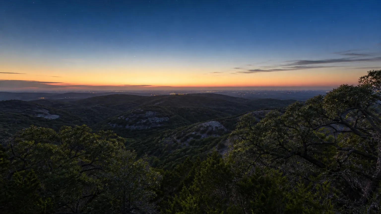 Austin, Texas: dusk from a western ridge with the distant glow of the city