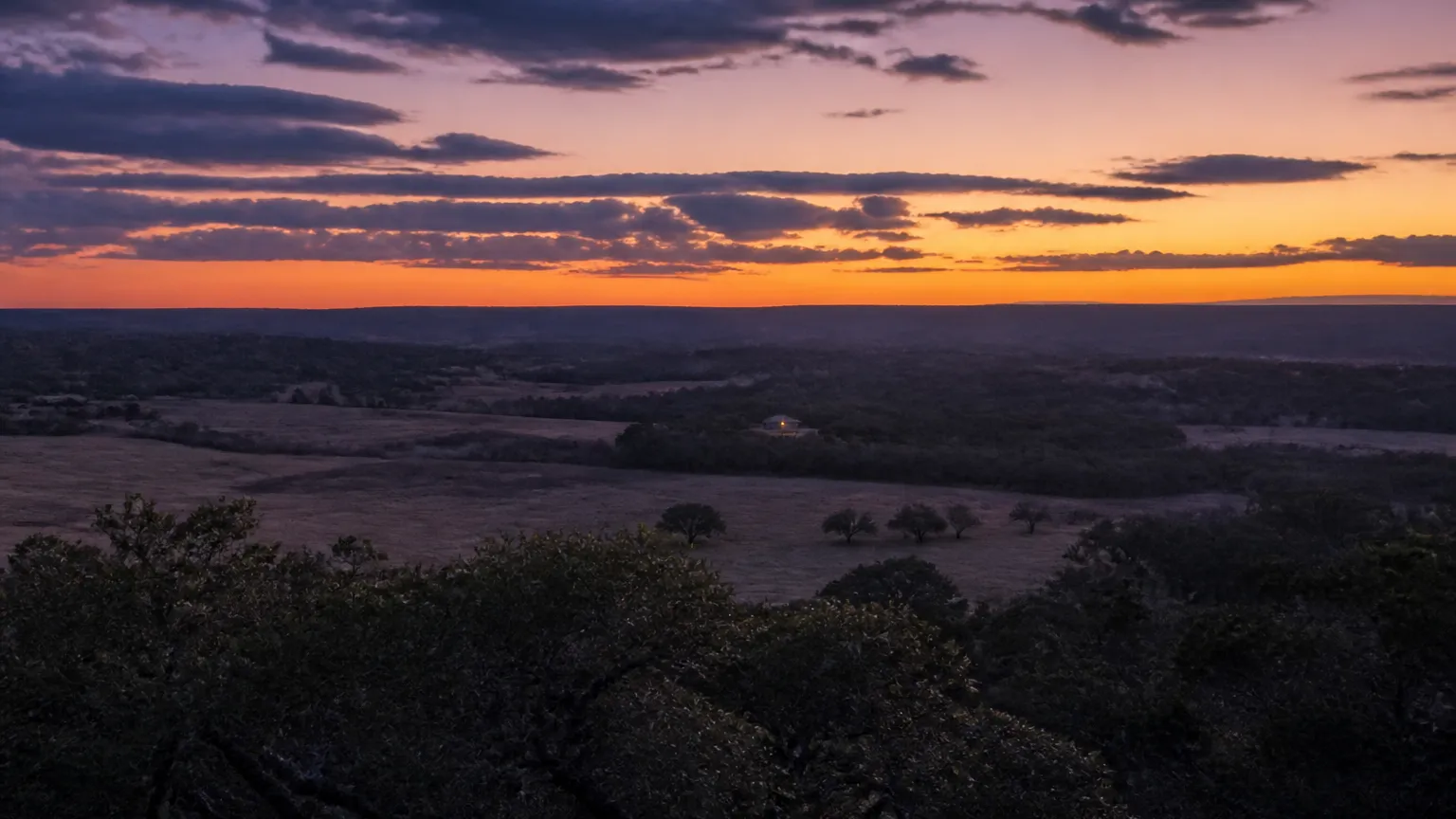 Driftwood, Texas: dusk vista over ranchland with silhouetted oak mottes