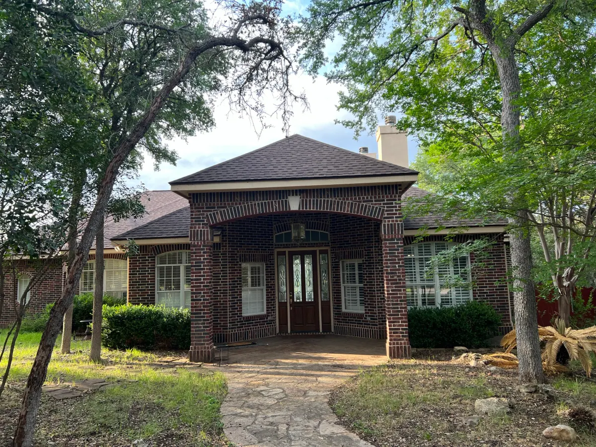 Completed whole-home luxury renovation in San Marcos, Texas: lime wash exterior and black steel windows at dusk